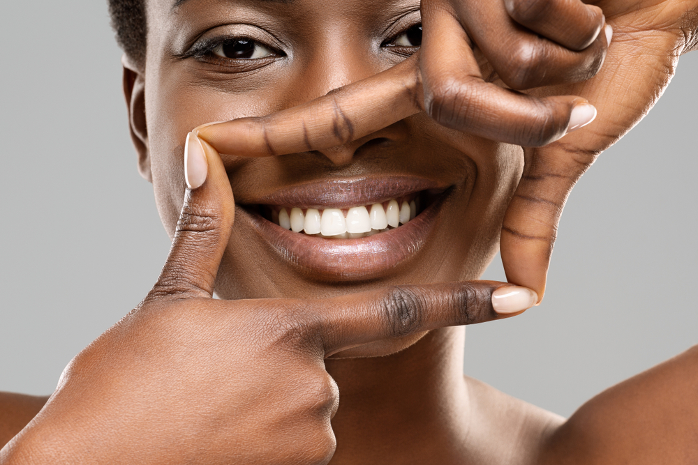 Confident Smile with Dental Bonding Close-up of a woman framing her smile with her fingers after a successful dental bonding treatment