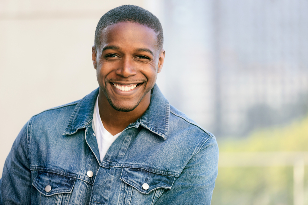 Bright Smile in Denim - Bellevue Cosmetic Dentistry A confident man in a denim jacket smiles outdoors with bright, even teeth, reflecting results from expert cosmetic dental care - Bellevue Cosmetic Dentistry