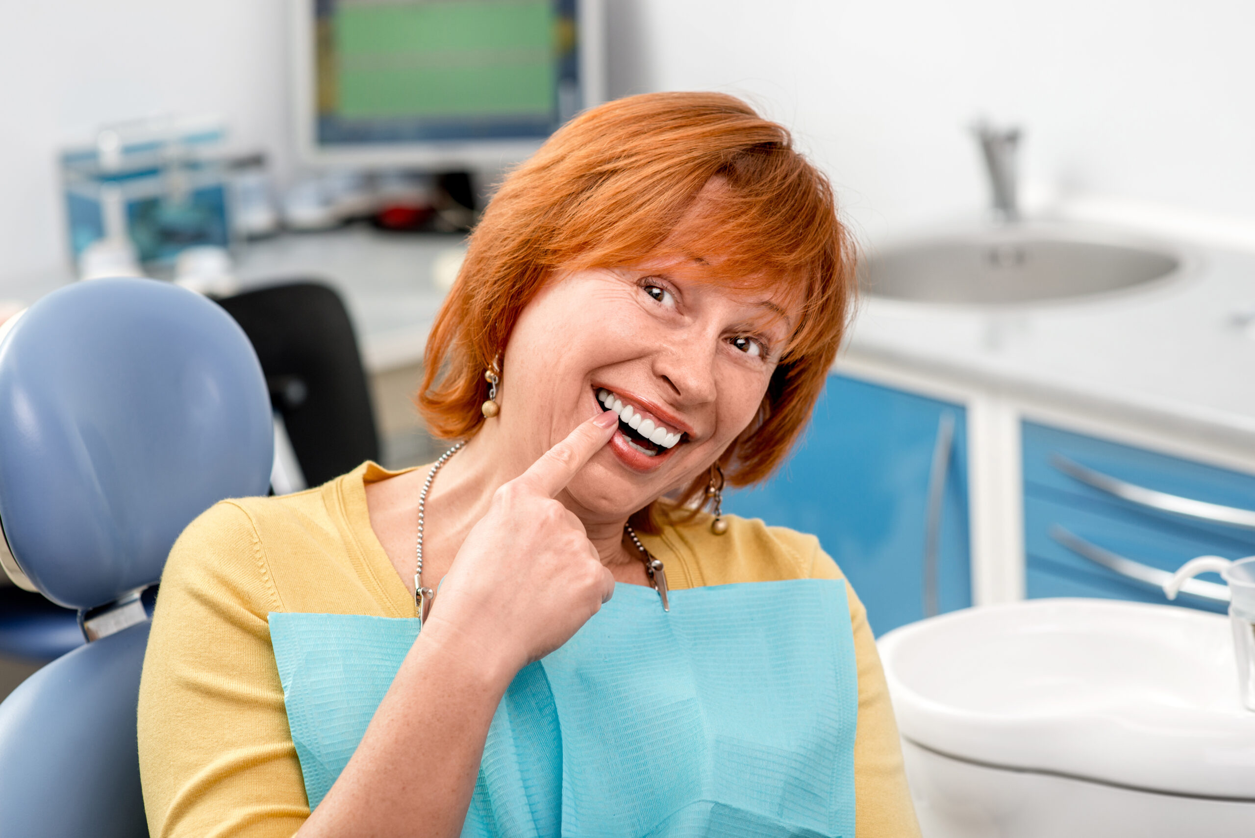 dental patient shows where her dental implant is placed