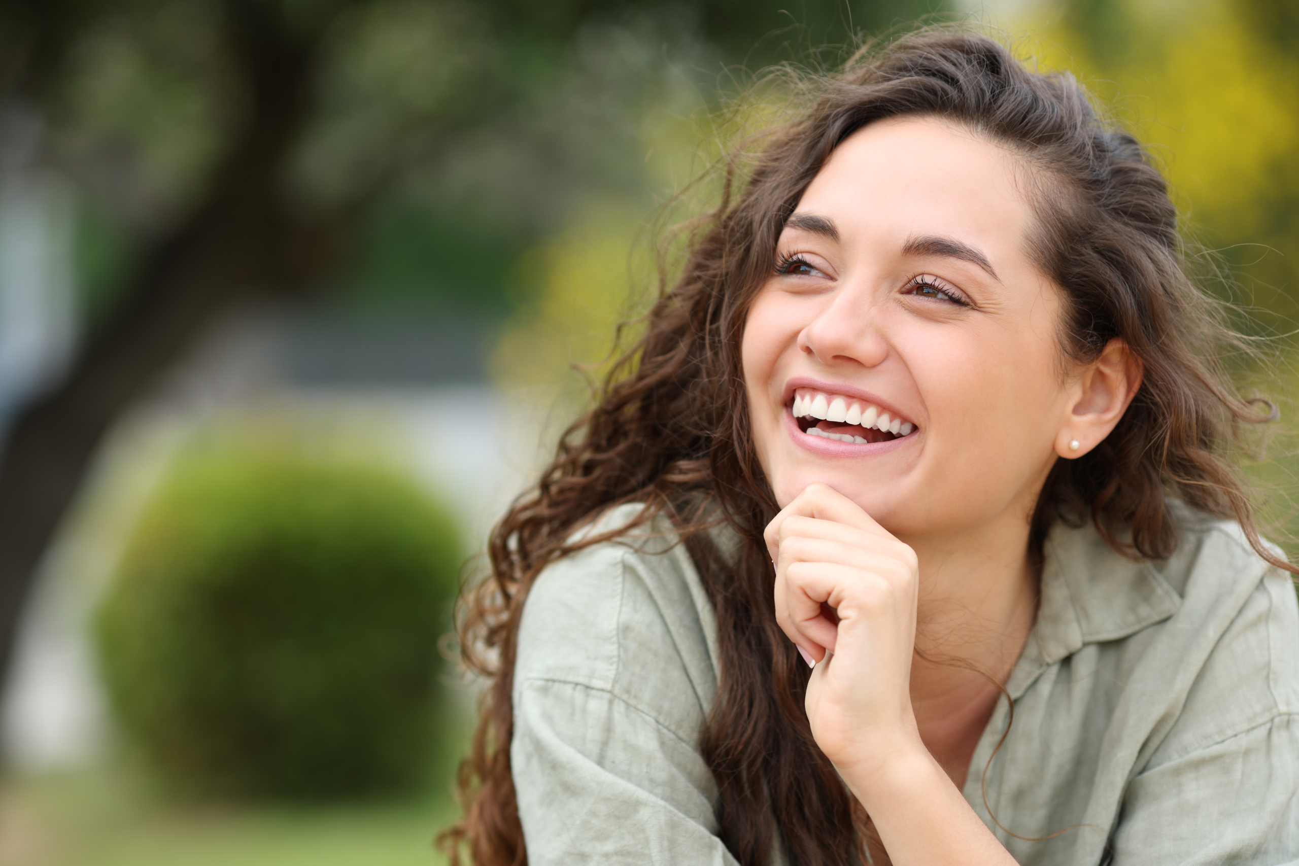 Confident Smiles with Natural-Looking Dental Crowns Woman smiling outdoors showing healthy, restored teeth with dental crowns