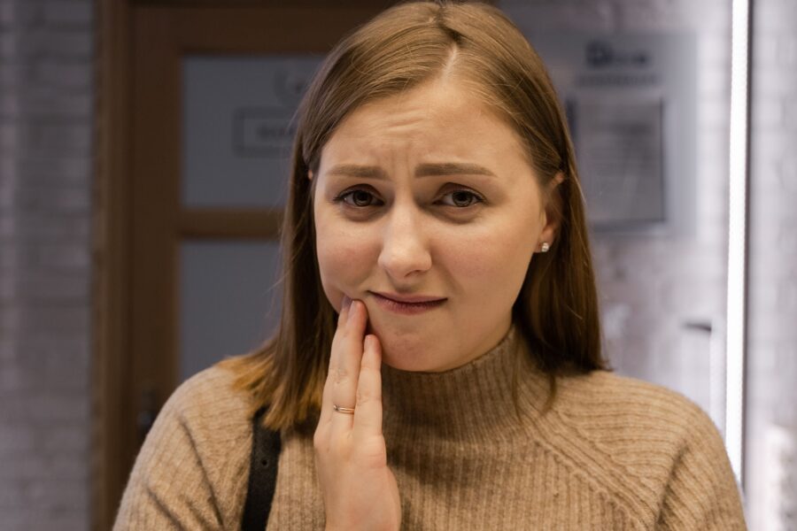 Woman wondering if her aching teeth counts as a dental emergency